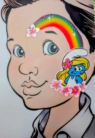Junge mit buntem Regenbogen und Schlümpfe-Aufkleber auf der Wange.